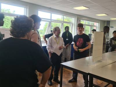 Physics students with their presentation in front of Professor David Bacon