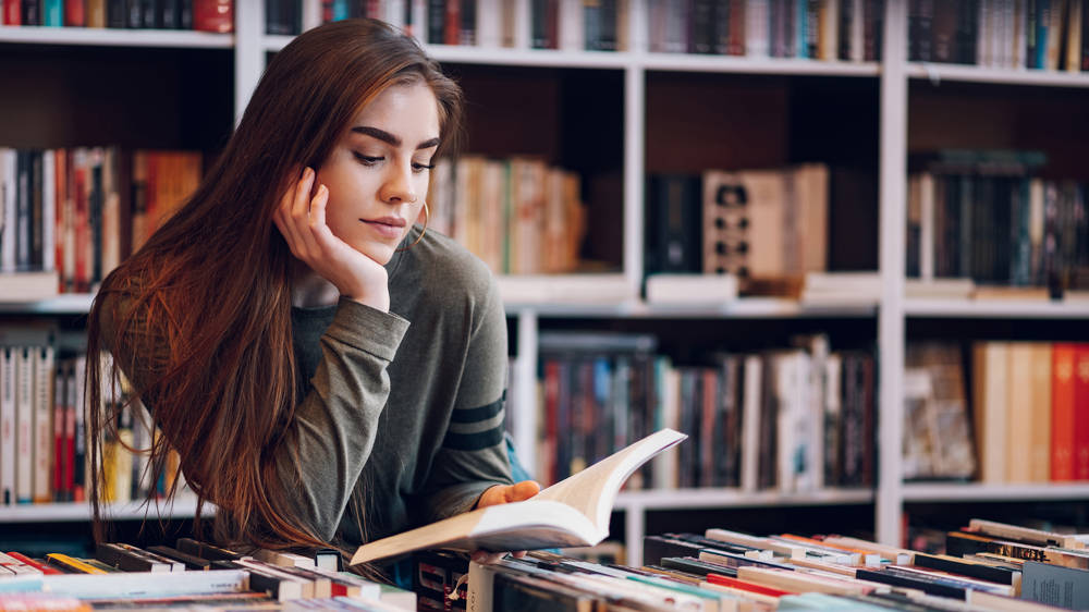 Female student reading book in the library