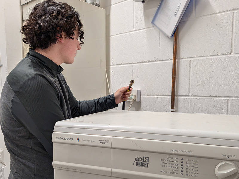 Gas engineer connecting and testing a gas tumble dryer during initial appliance training and assessment for LAU1.