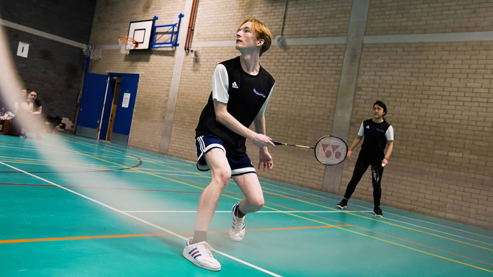 Sports students playing badminton pairs match in the sports hall at Sixth Form campus 