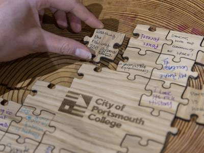 A guest places a puzzle piece on the immersive art installation at the COPC x Unloc dinner