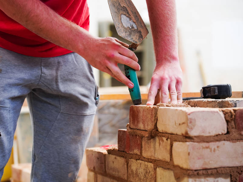 Bricklaying student building wall in the workshop at North Harbour Campus.