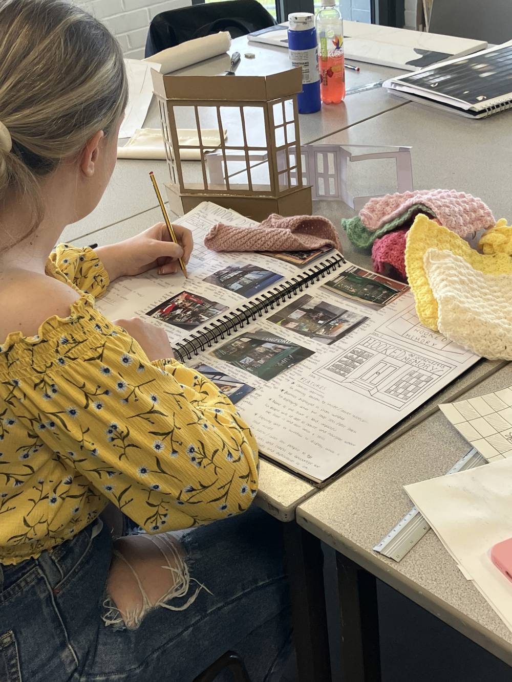 Student working on their course work in sketch book whilst in the art studio.