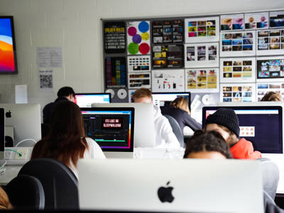 Students working on Mac computers in an art and design classroom