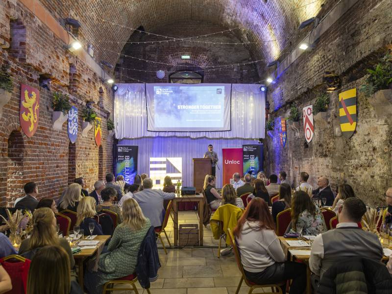 guests at the COPC and Unloc community dinner hearing from guest speaker Motaz Amer