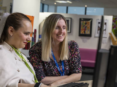 A COPC staff member helping a student on a computer