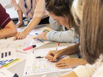 Students completing accounting worksheets at a table 
